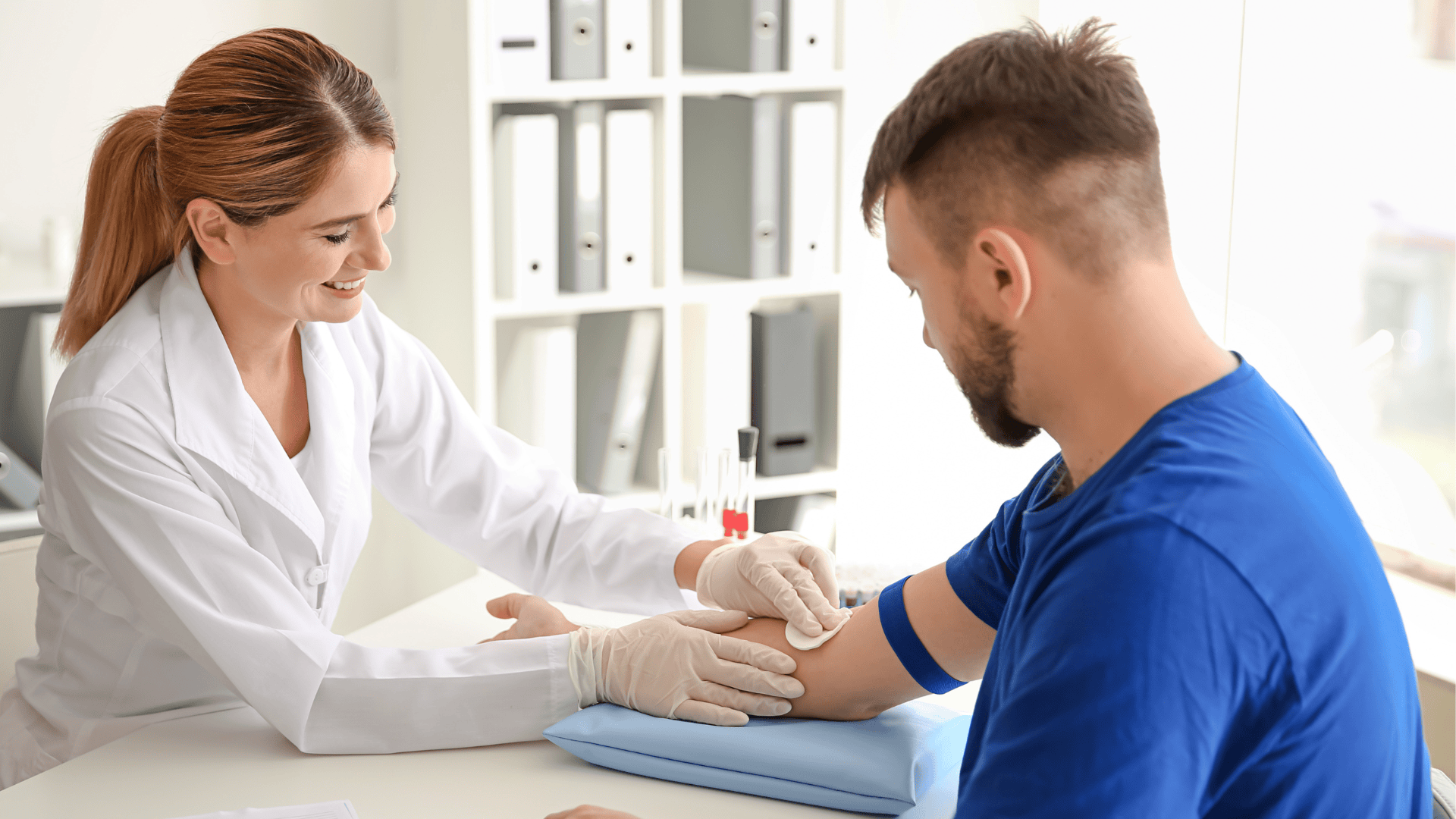 Phlebotomy student practicing venipuncture on individual.